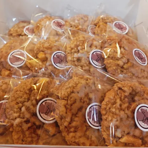 Oat-studded glazed cookies, each in its own clear bag with a round SM sticker